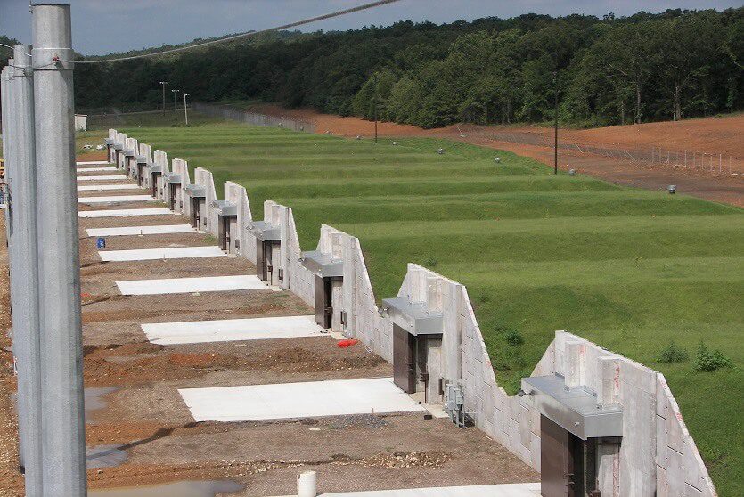 A row of concrete benches in front of a field.